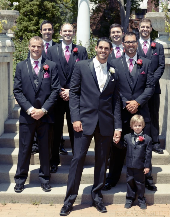 a group of men in suits stand on steps