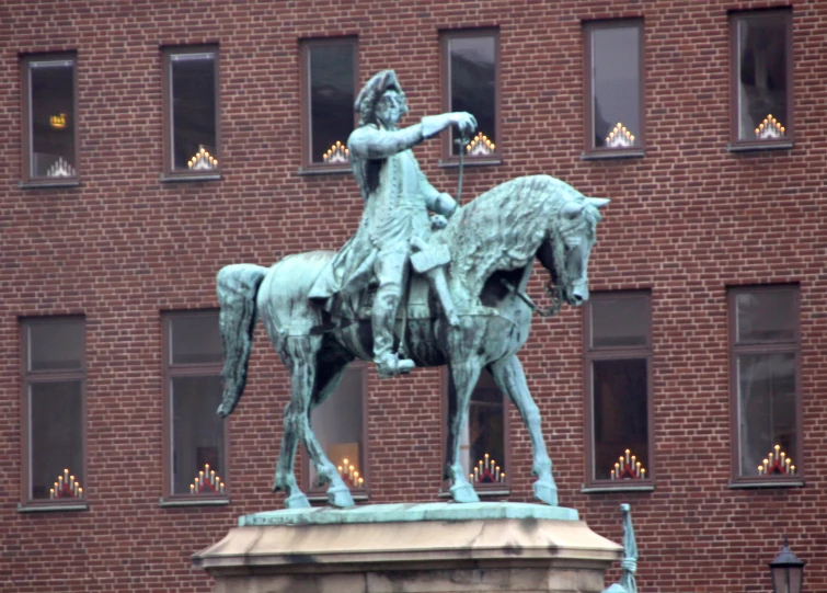 a statue of a girl is standing on the horse