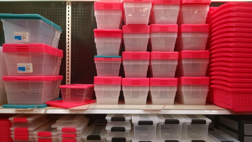 lots of clear and pink plastic containers are stacked on a shelf