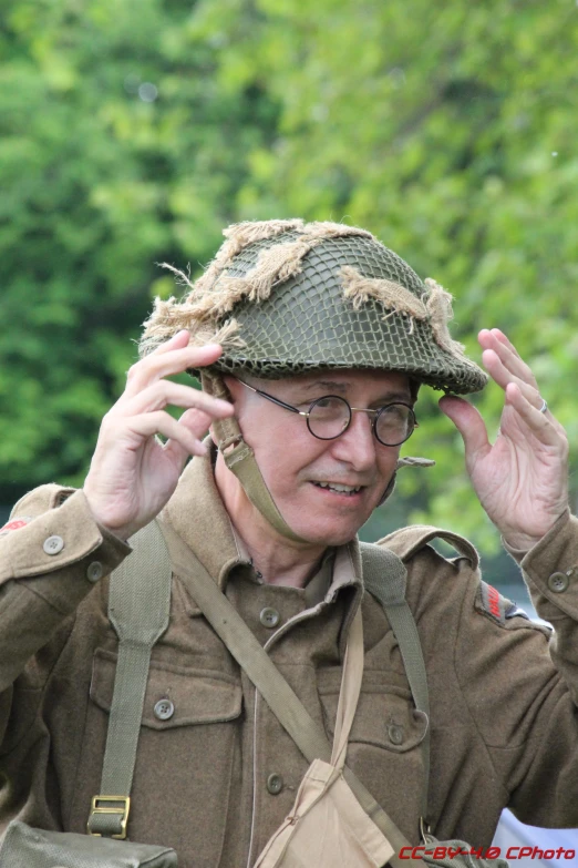 a man in a uniform holding a hat on his head