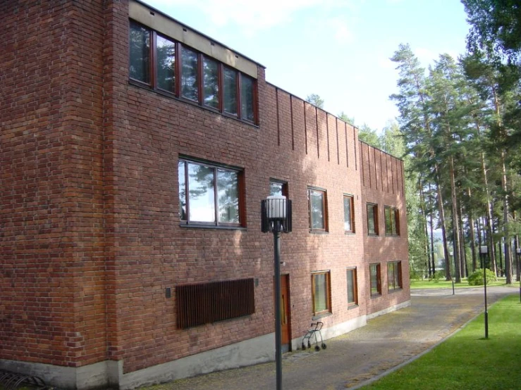 the side of a building with tall windows and a street light in front