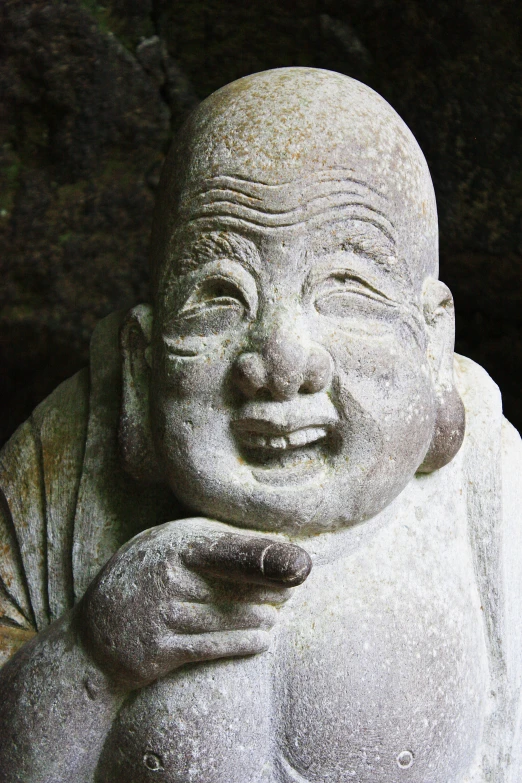 an old laughing buddha with hands together