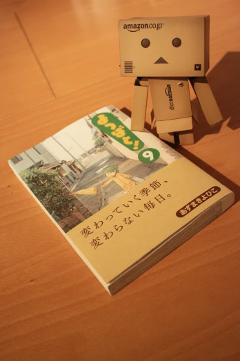 a little paper toy and an amazon book on a table