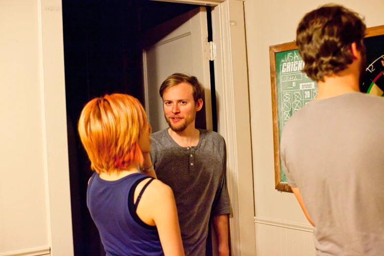 a woman talking to a man in a doorway