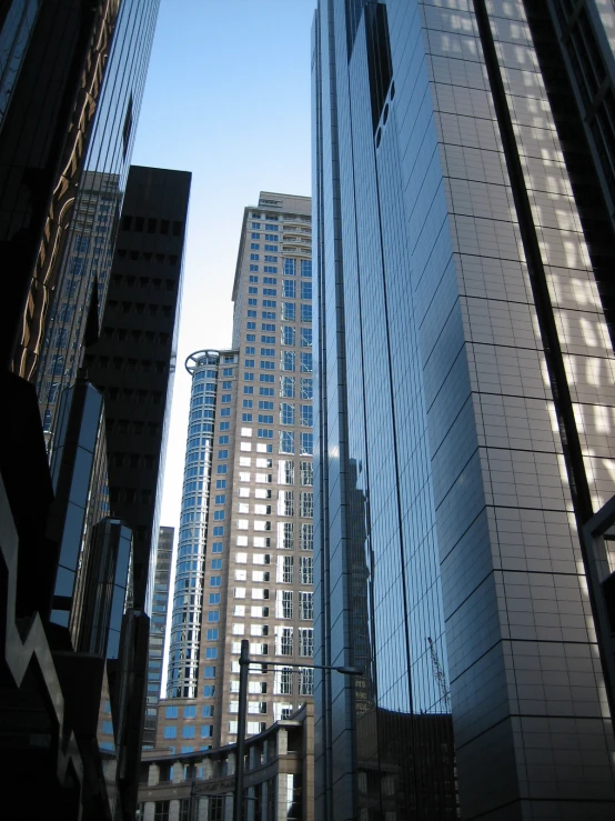 the sky reflects off of some tall buildings