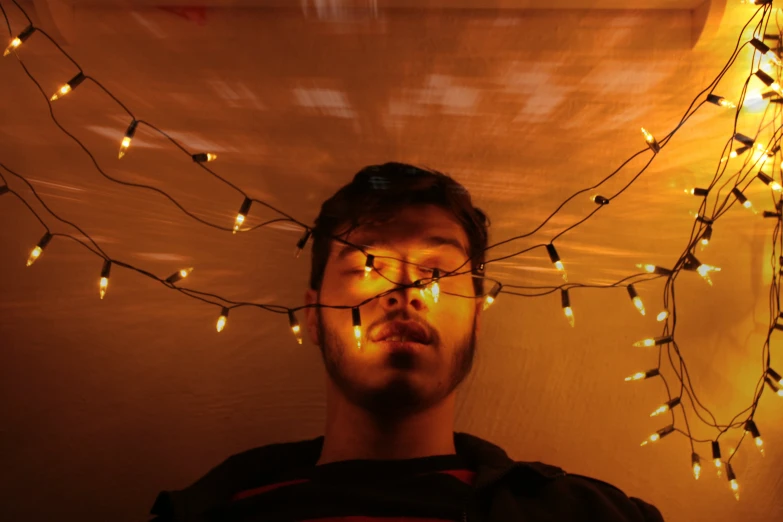 a man stares into the camera, with the lights all over him