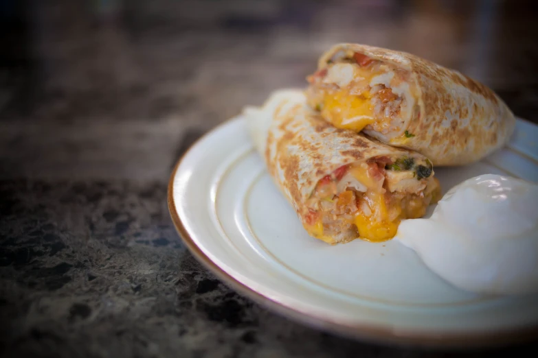 a plate with a burrito and some yogurt