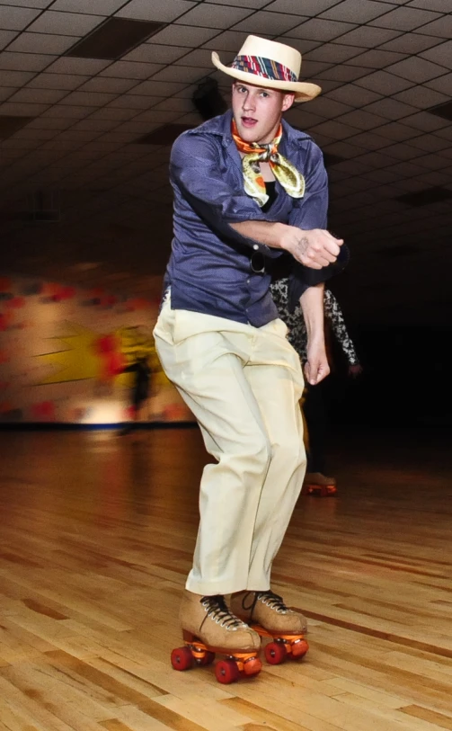 a man in a cowboy hat skating down a wooden floor