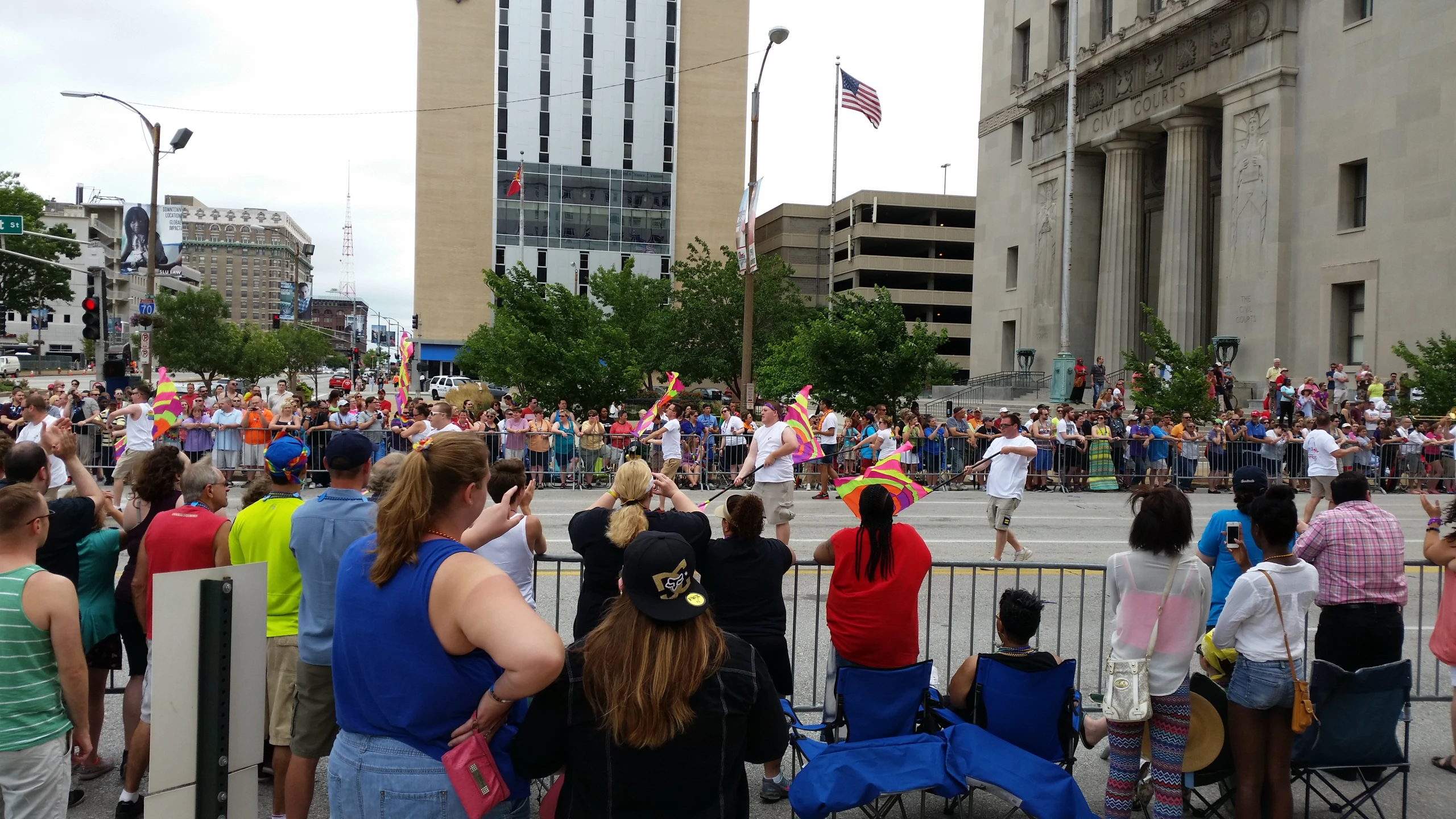 group of people at street corner with one woman facing towards the crowd