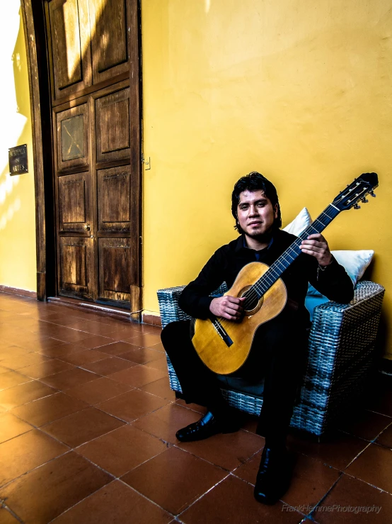 man sitting on the floor with a guitar