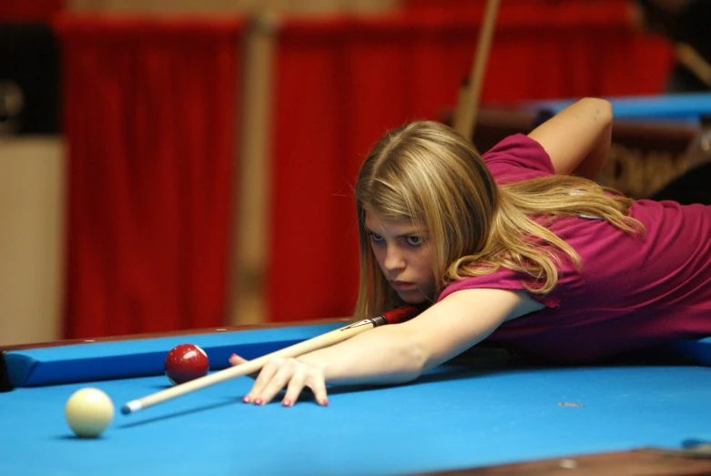 a girl playing pool in a large event