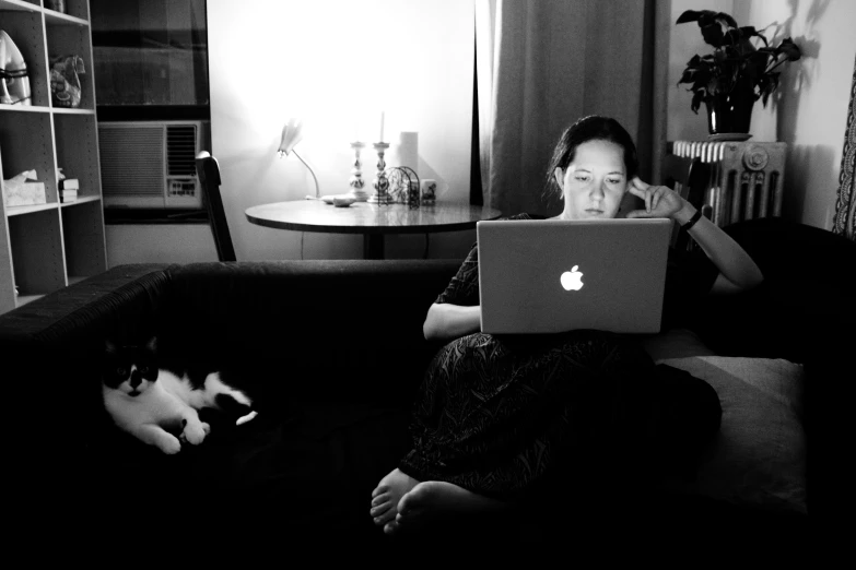 woman sitting on couch using apple laptop computer