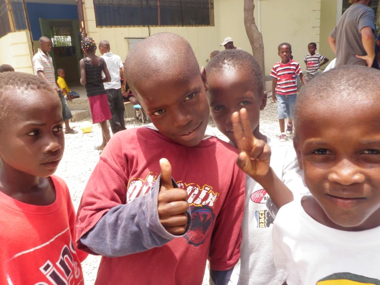 five children pose with their hand and thumb signs