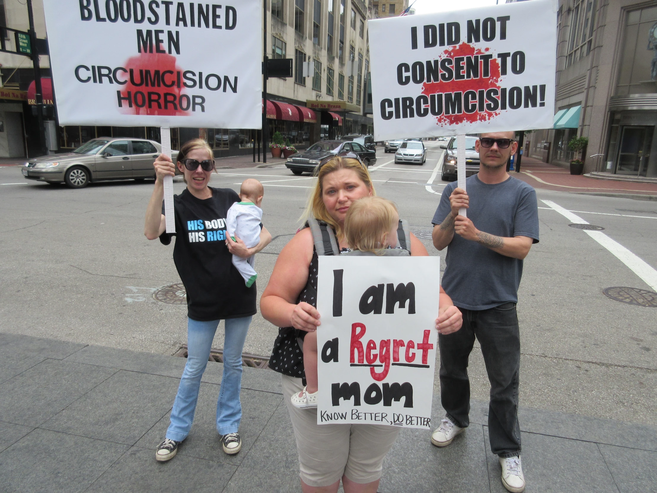 some people holding signs in the street and a car