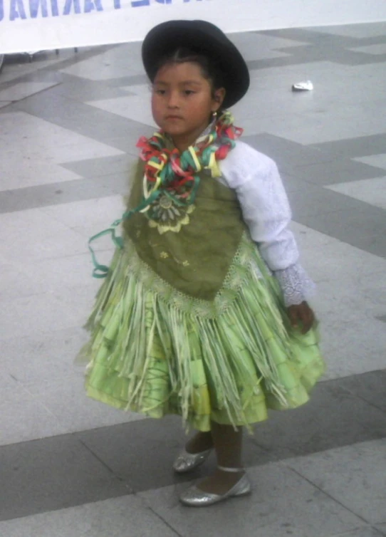 a little girl wearing a dress and hat