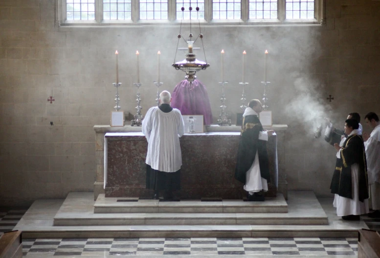 priest standing in front of a podium with an altar and pews