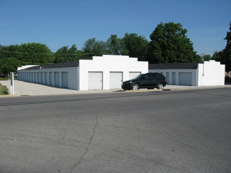 a car parked in front of two storage units on the side of a street