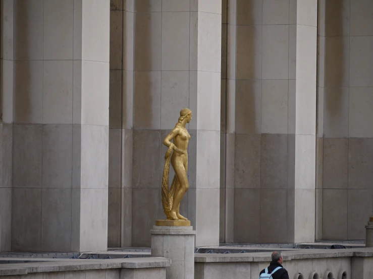 a statue of a woman next to several gray columns