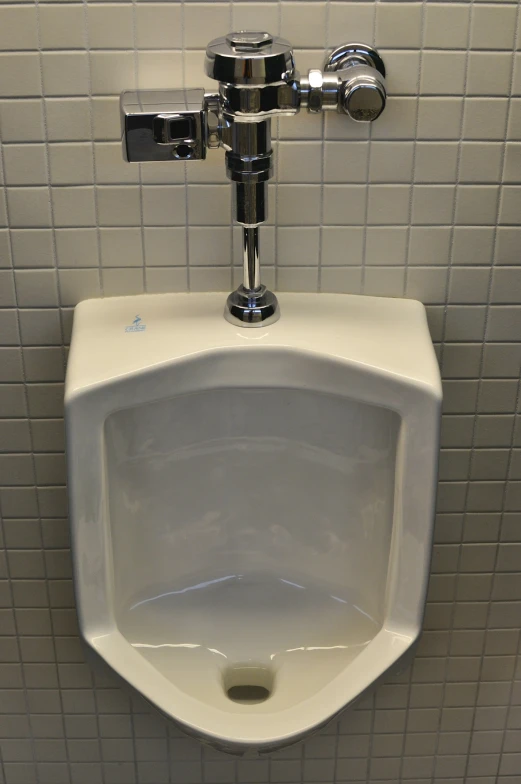 a urinal mounted to a wall next to tiles
