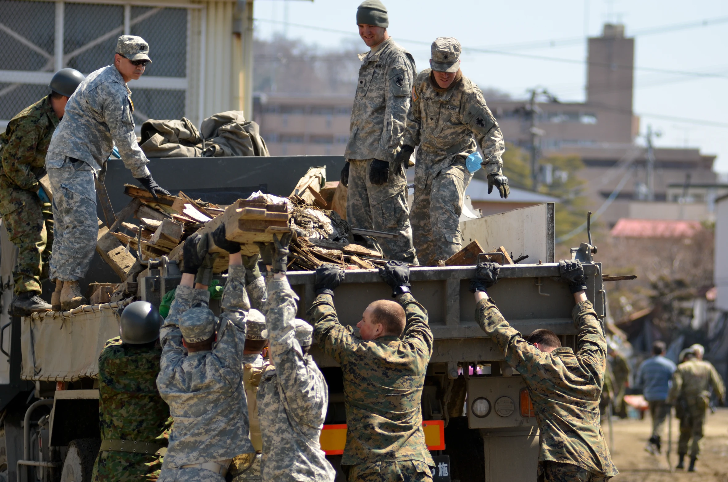 soldiers and civilians are riding in the back of a truck