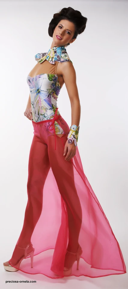 a woman wearing red pants and a shirt with flowers