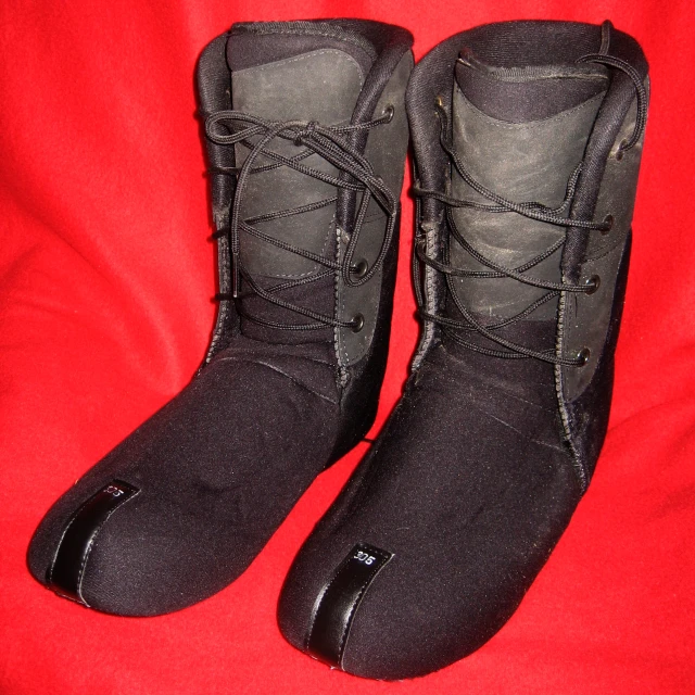 a pair of black boots on a red fabric