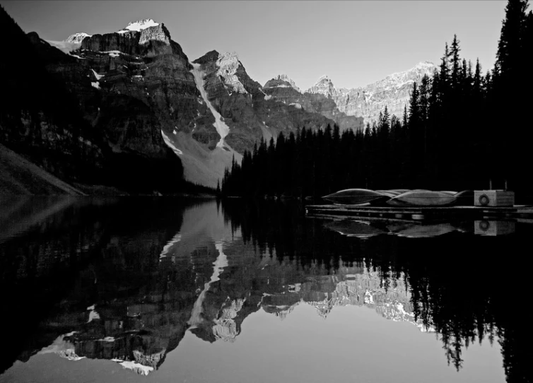 mountains and trees reflected in water with a forest below