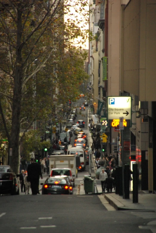 a city street filled with lots of traffic and people walking around