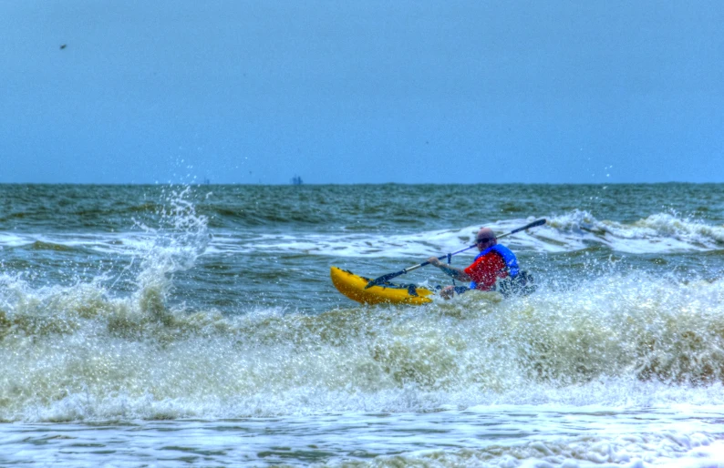 a person is riding on top of a yellow kayak