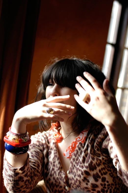 a woman putting her hands together in front of a window