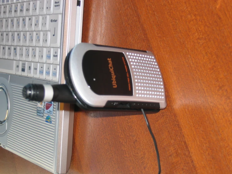 a radio is sitting next to a laptop on a wooden table