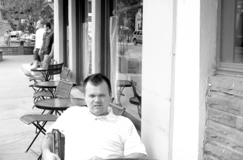 a man sitting at a table outside a restaurant