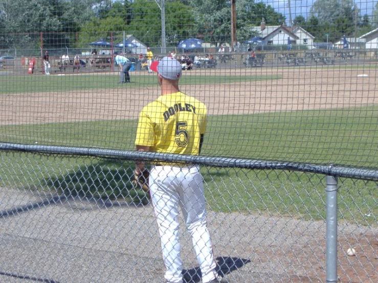 a baseball player in yellow is standing at the field