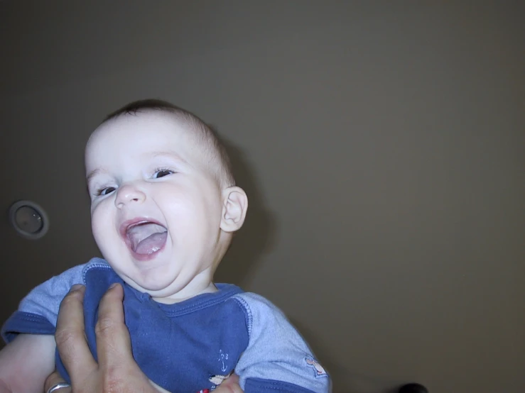 the young man holds his baby and laughs