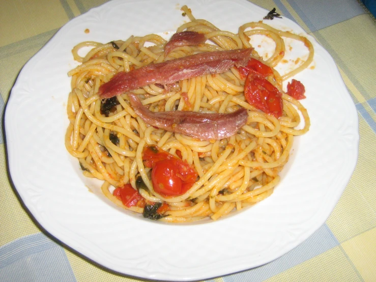 the spaghetti is topped with tomatoes, bacon, and toast