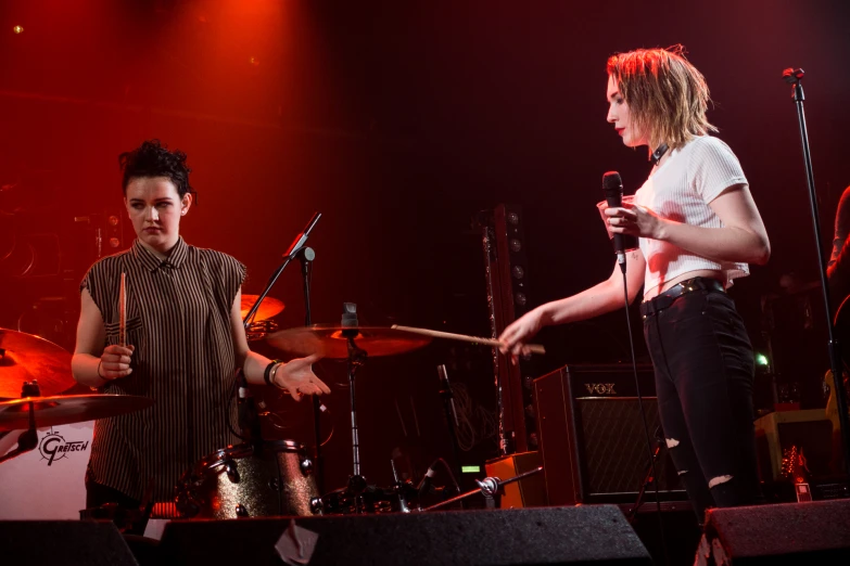 two people standing on stage with instruments