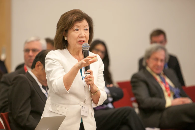 a woman standing at a podium with a microphone