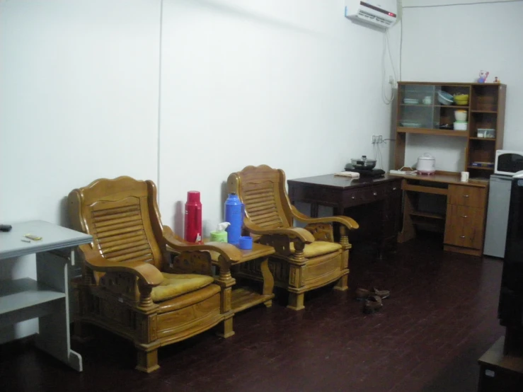 a wooden room with chairs, shelves, and computer on the desk