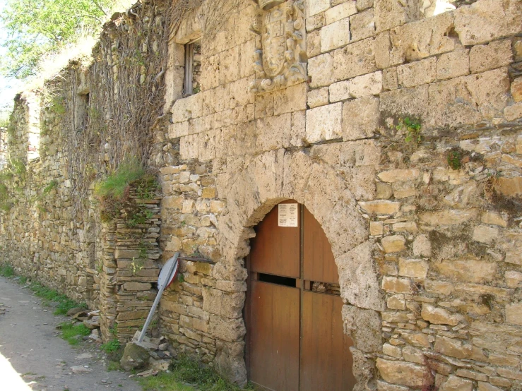 a brick wall is surrounding an open door with a small sign that reads no dogs