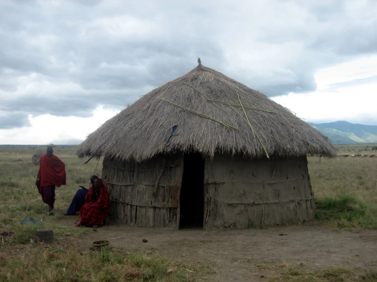 some people are standing in a field near a building