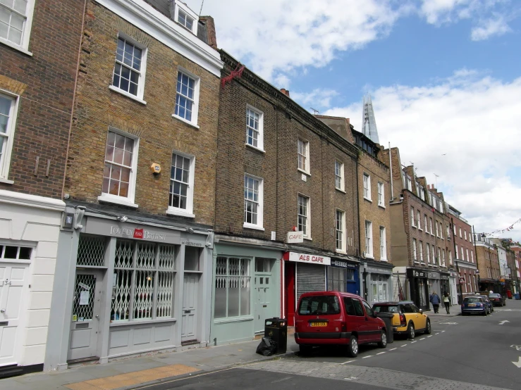 row of browns on a residential street lined with parked cars