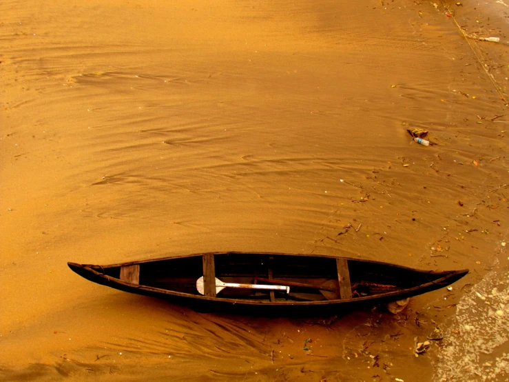 a small boat sitting on top of a sandy beach