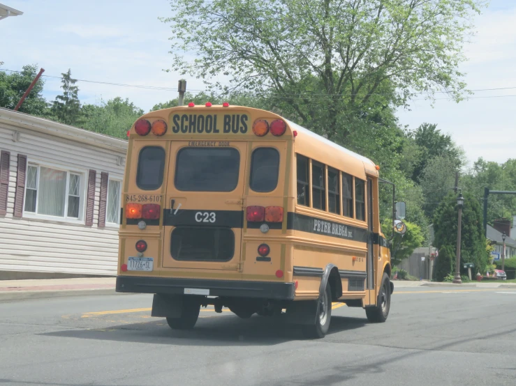 a yellow school bus drives down the street