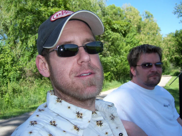 two men riding down the road in sun glasses