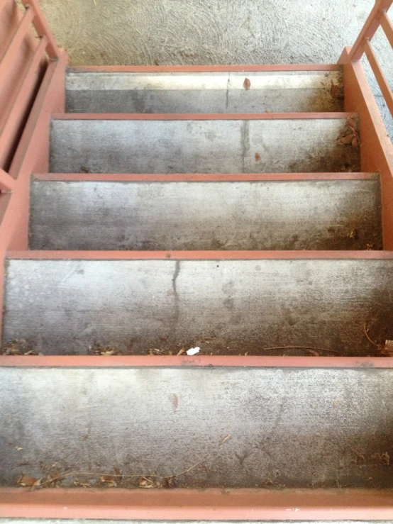 concrete stairs with brown carpet in an old building