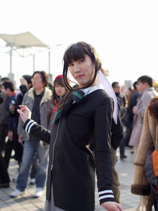 a girl dressed up is standing outside with crowd behind her