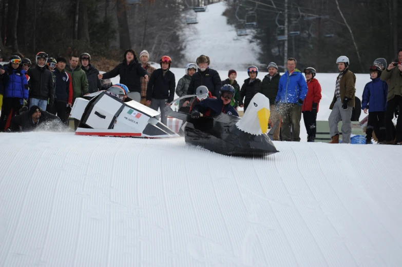 a group of people gathered around the snow in a ski slope