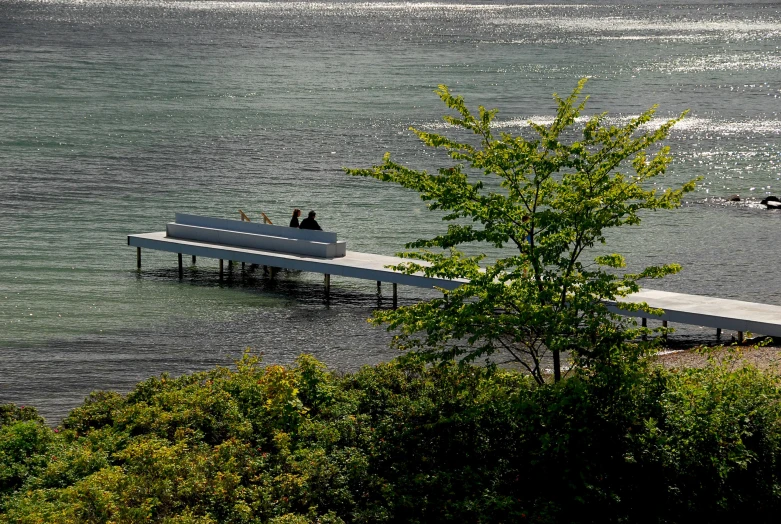 an elevated bench is on a lake shore