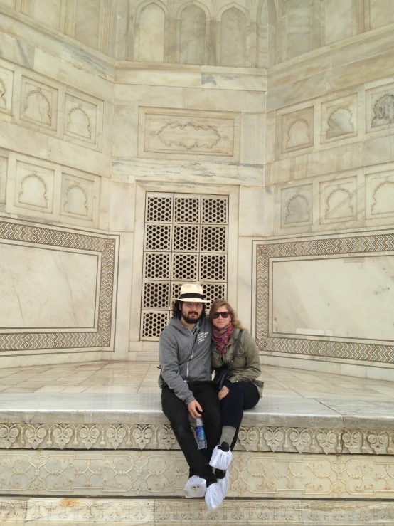 a man and a woman sitting together on some stone steps