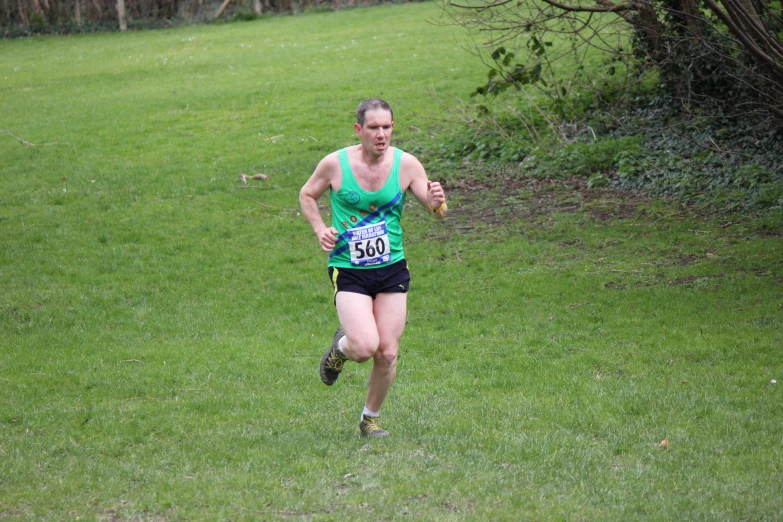 a female running on a grassy surface in a tight stance